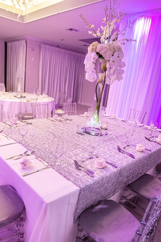 White orchids, shimmering silver linens and carefully placed glassware bring a romantic finishing touch to the celebration.