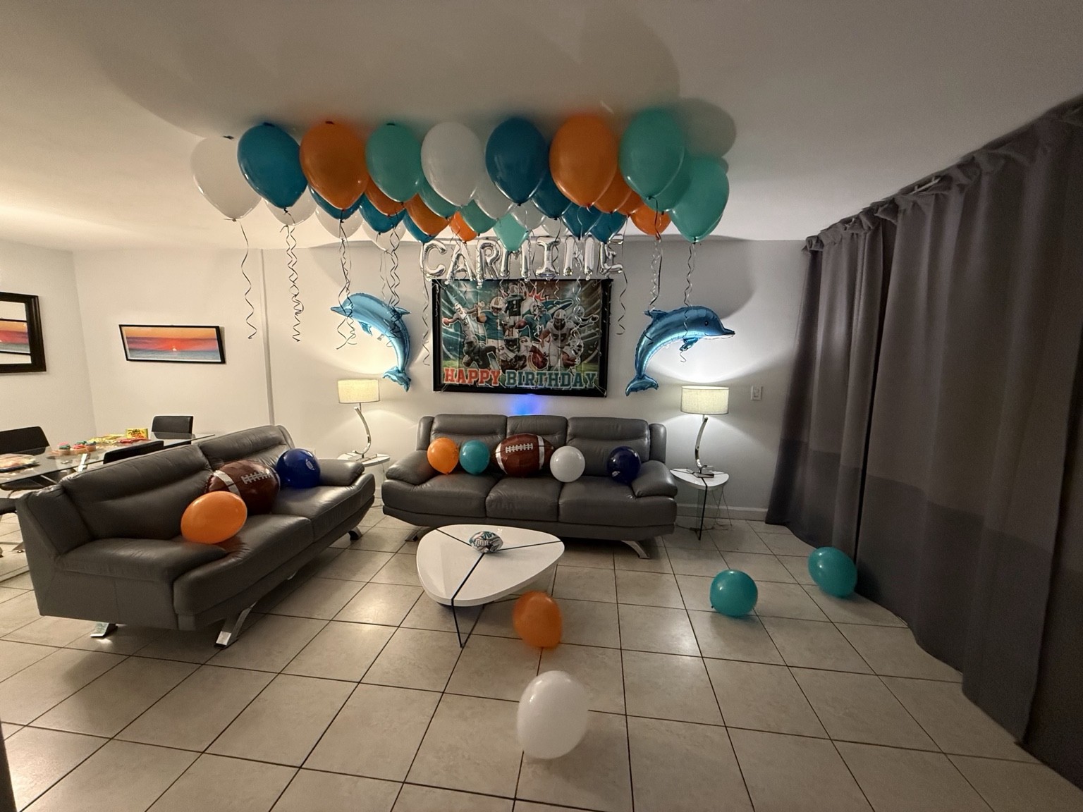 A wide view of a birthday room styled in team colors, with personalized balloons and room to celebrate.